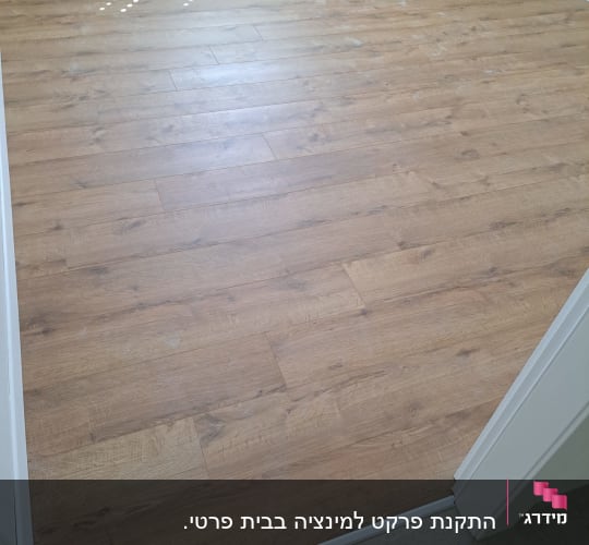 רצפת פרקט עץ בחדר ריק עם מסגרת לבנה